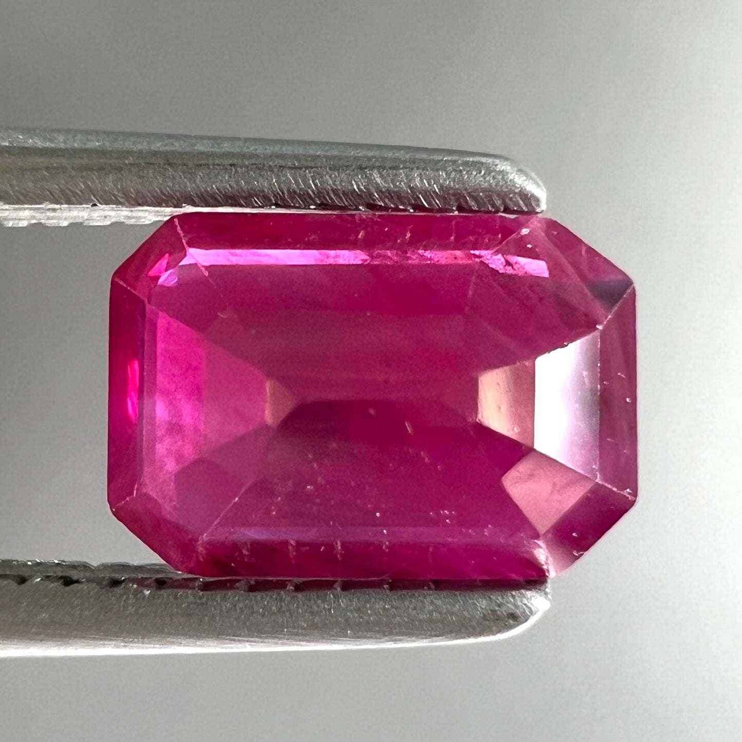 A natural, emerald cut Burma ruby gemstone.  The stone is pinkish red color.