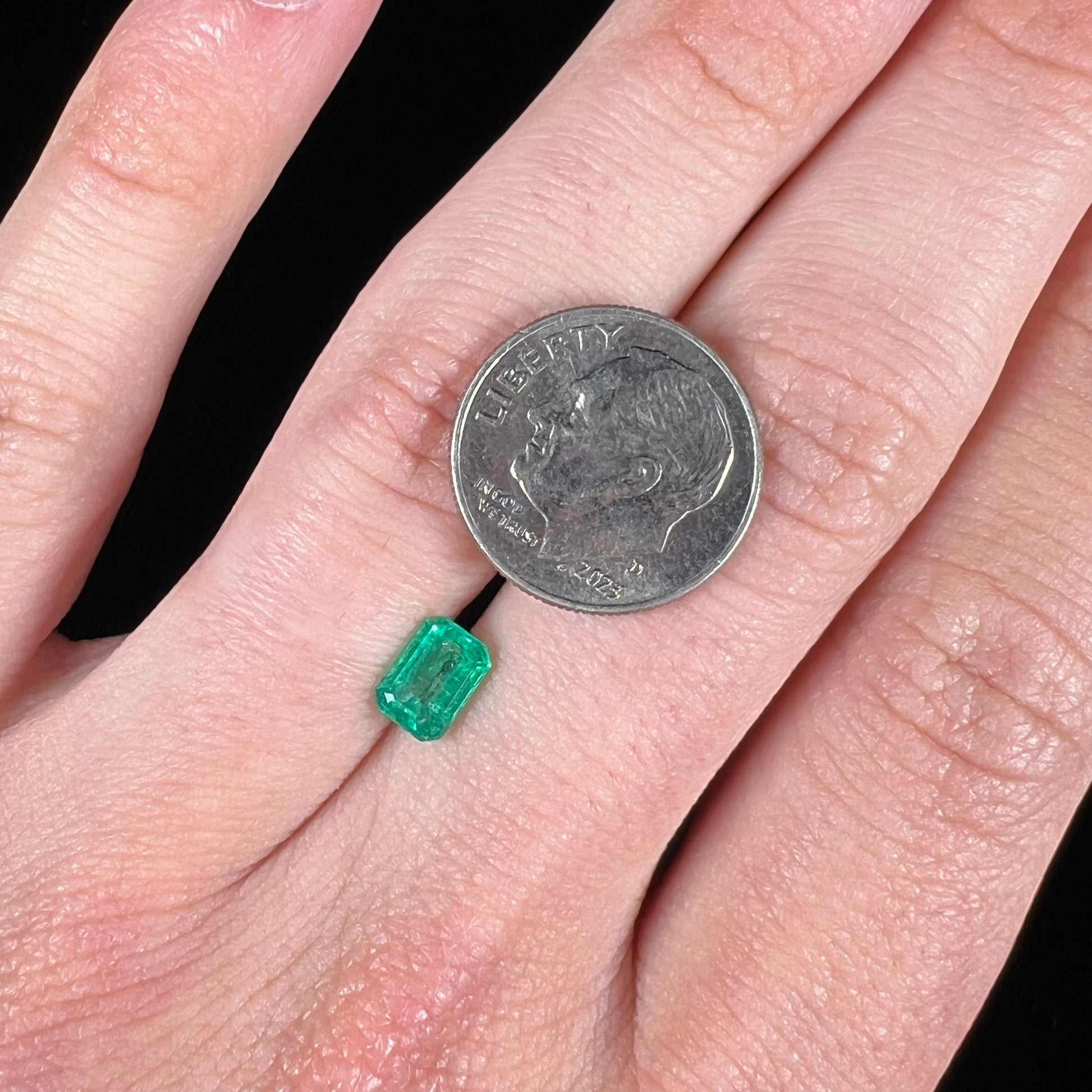 A loose, natural emerald gemstone.  The stone is emerald cut.