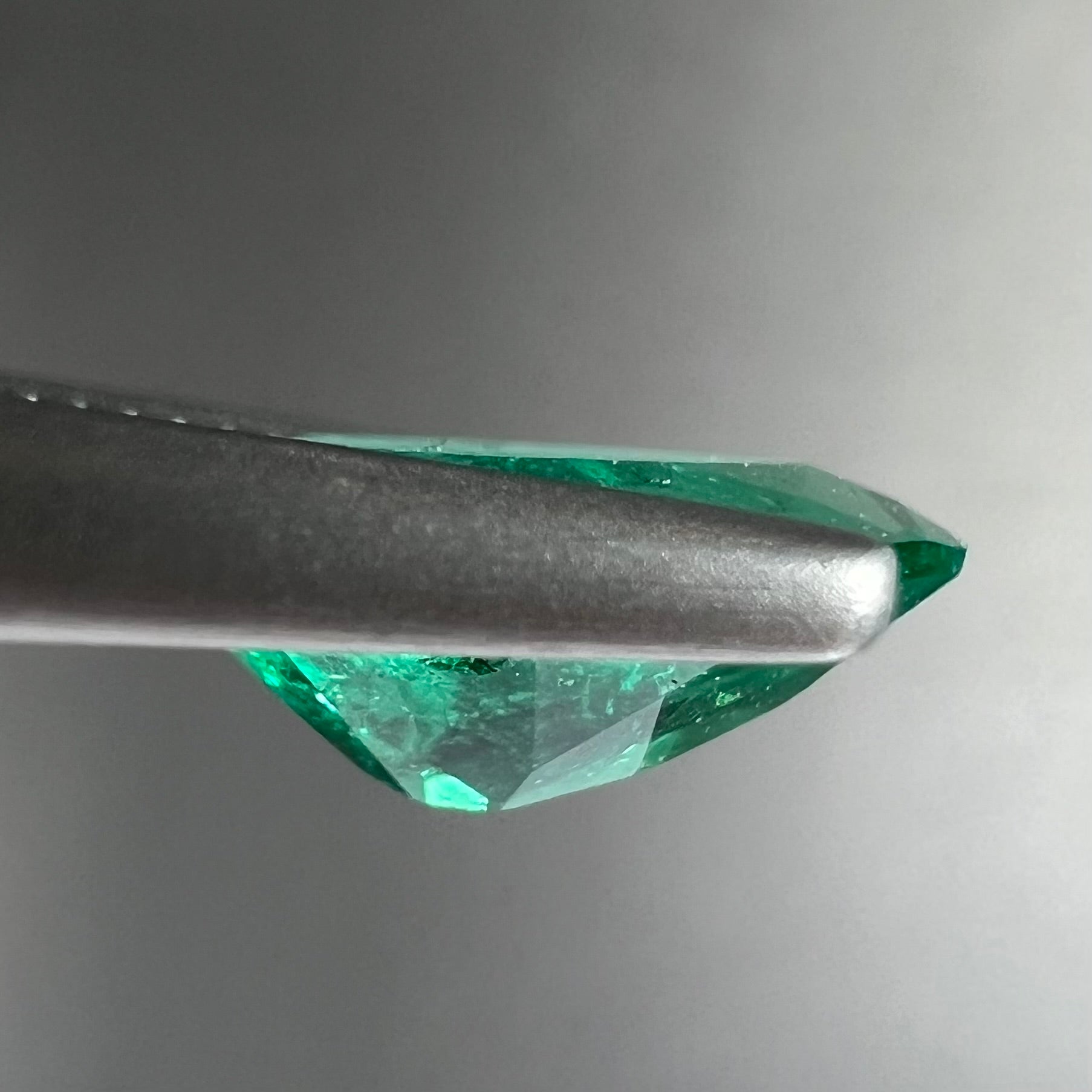 A loose, pear shaped natural emerald gemstone.