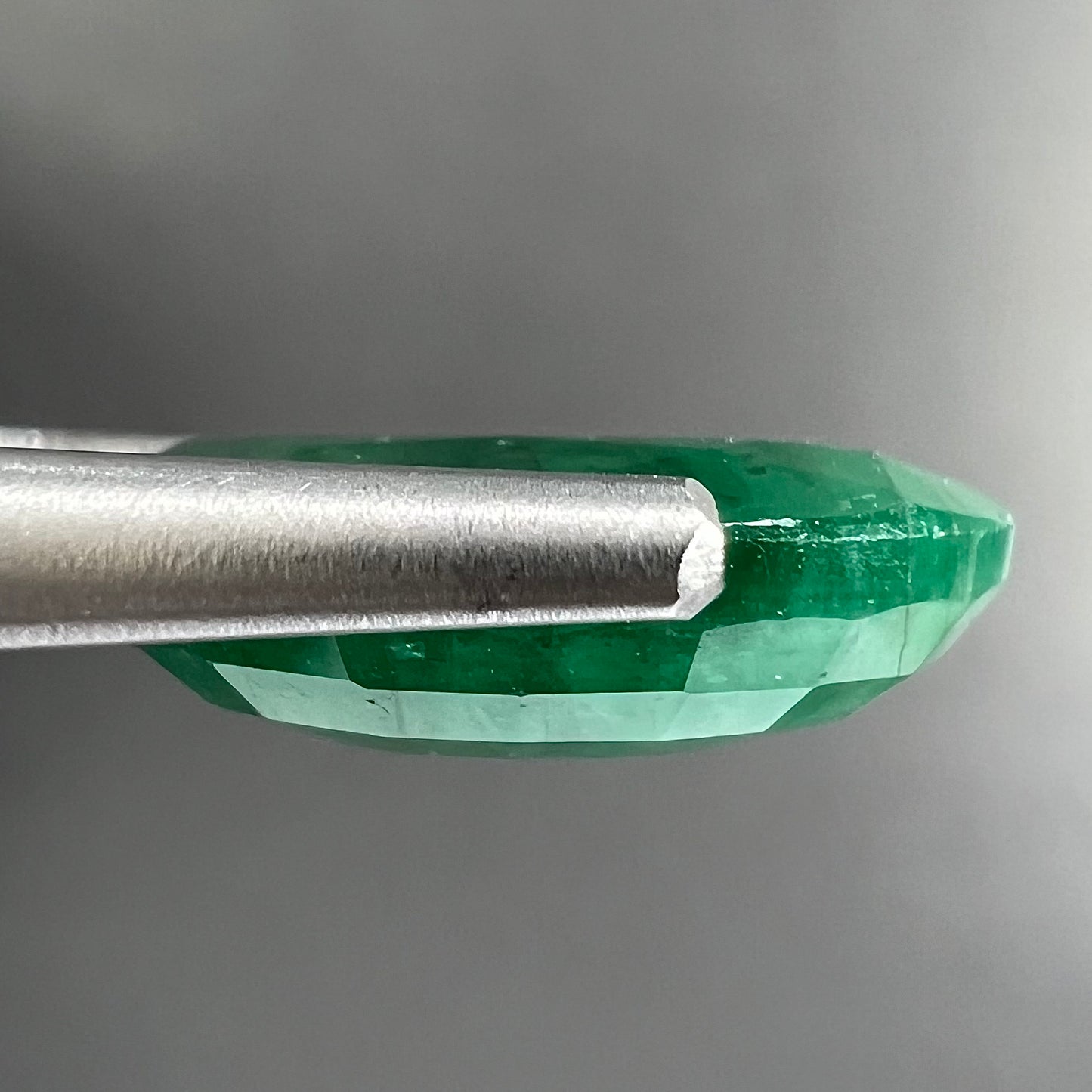 A loose, faceted oval cut commercial grade emerald stone.