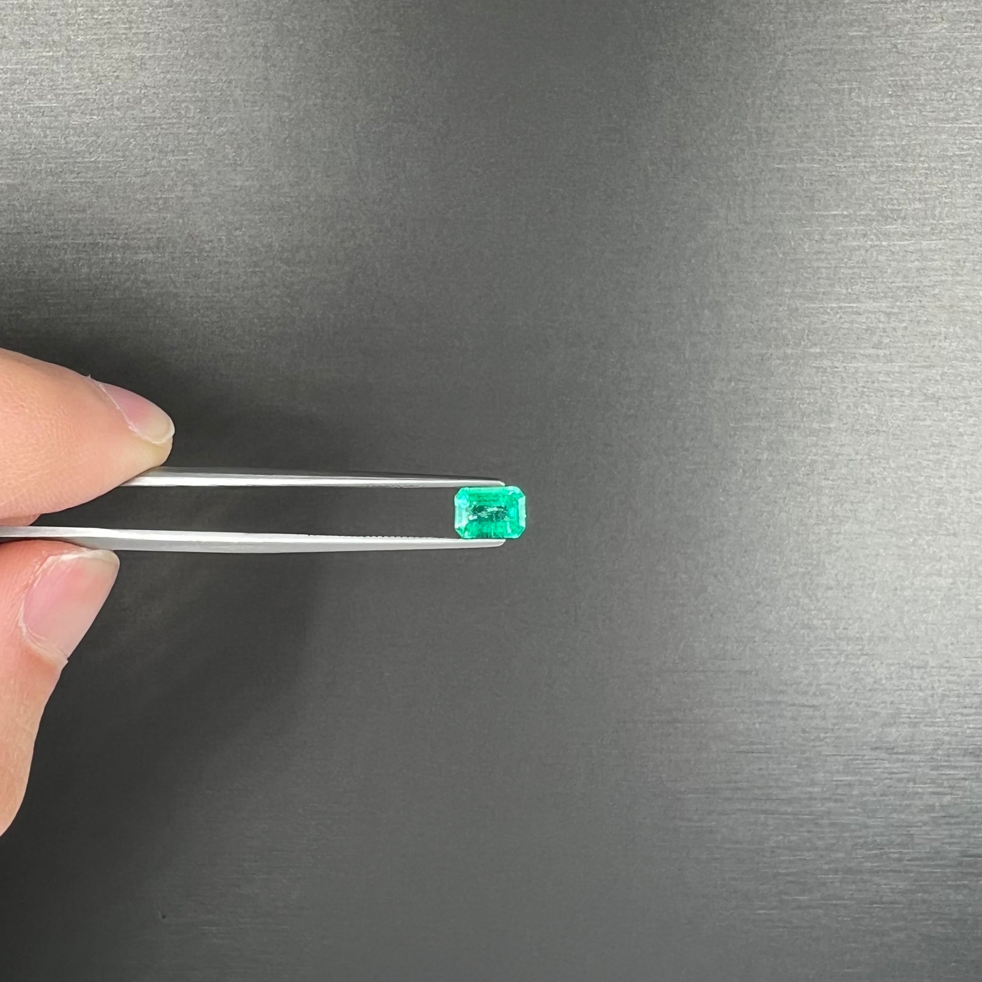 A loose, natural emerald gemstone.  The stone is emerald cut.