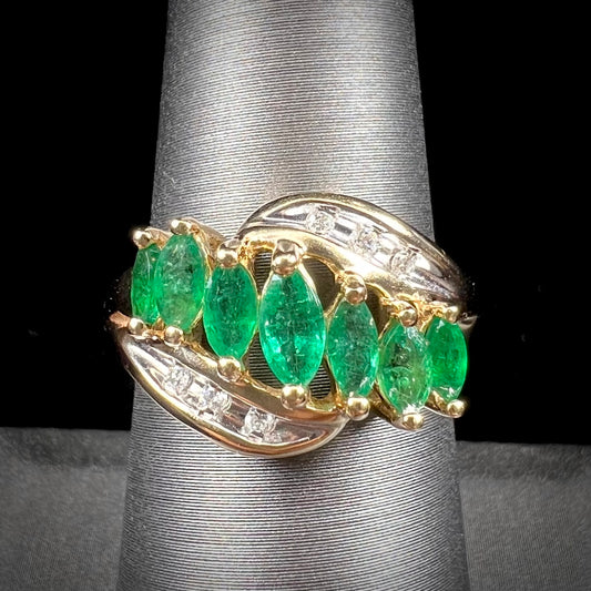 A vintage, 1970's style yellow gold ring set with marquise cut emeralds and round brilliant cut diamonds.