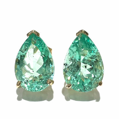 A pair of yellow gold stud earrings set with natural, pear shaped emeralds.