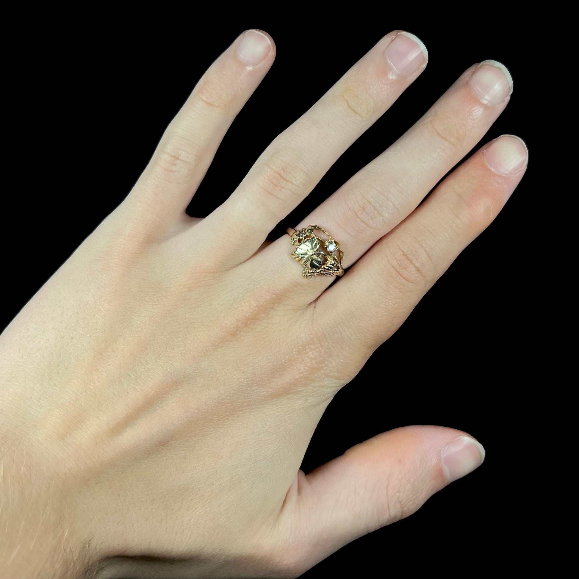 A ladies' two tone rose and yellow gold Black Hills gold diamond ring.  The ring exhibits a leaf design.