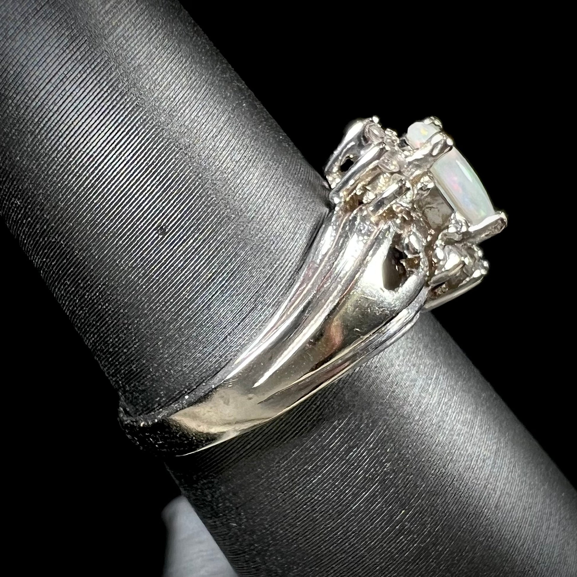 A ladies' white gold ring set with a halo of diamonds and an oval cabochon cut Australian opal.