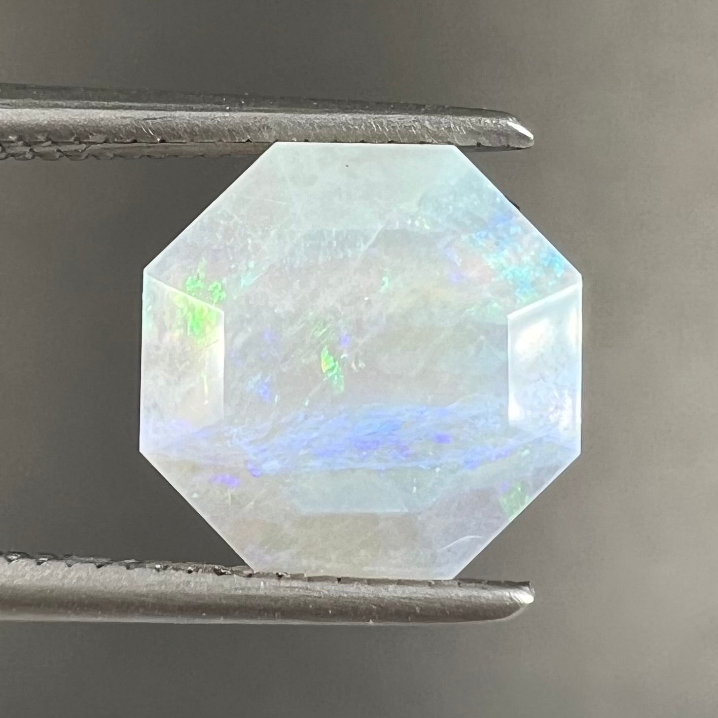 A loose, faceted octagon gray base crystal opal from Lightning Ridge, Australia.
