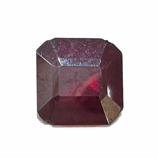A loose, modified Asscher cut cuprite gemstone.  The stone is a deep, crimson red color and has several chips along the girdle.
