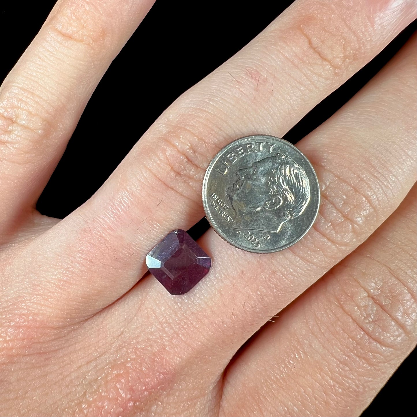 A loose, modified Asscher cut cuprite gemstone.  The stone is a deep, crimson red color and has several chips along the girdle.