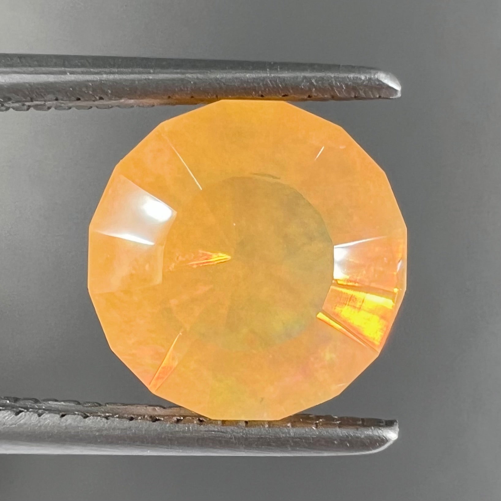 A loose, faceted round cut fire opal from Mexico.  The stone is yellow orange in body color.