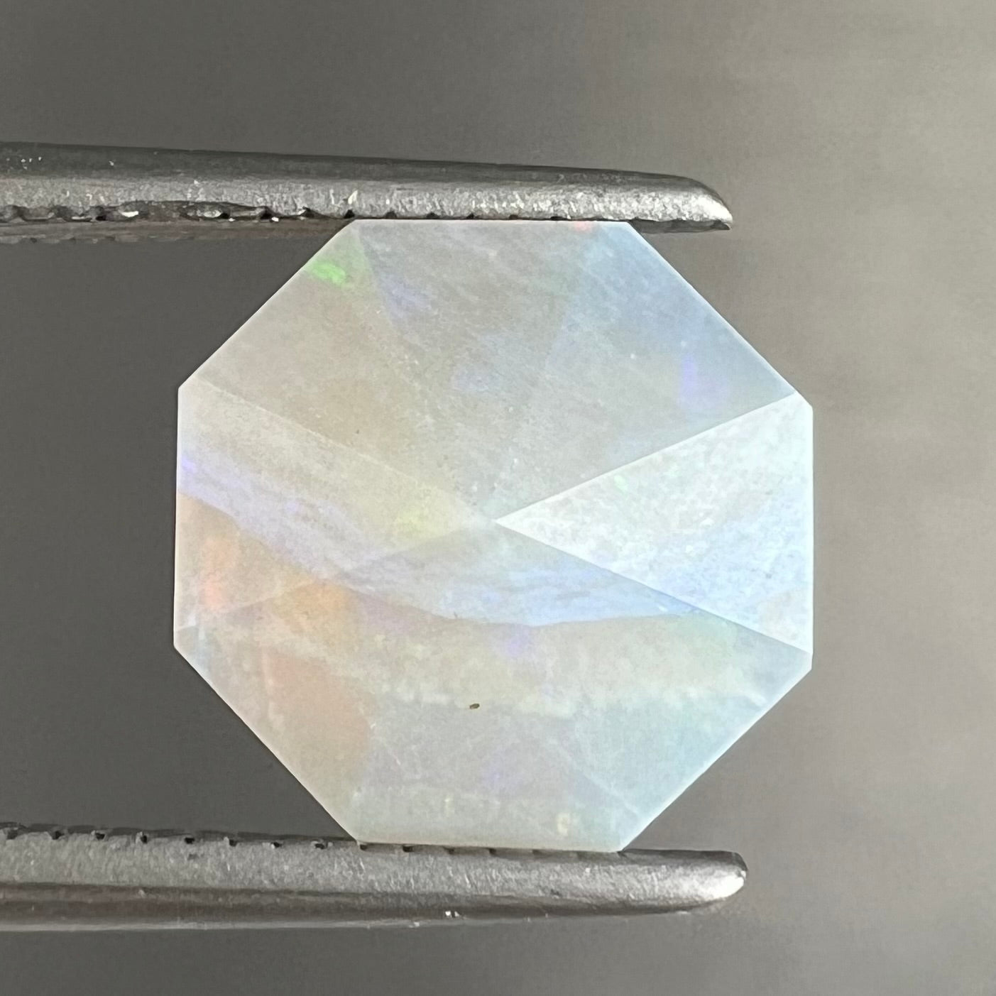 A loose, faceted octagon gray base crystal opal from Lightning Ridge, Australia.