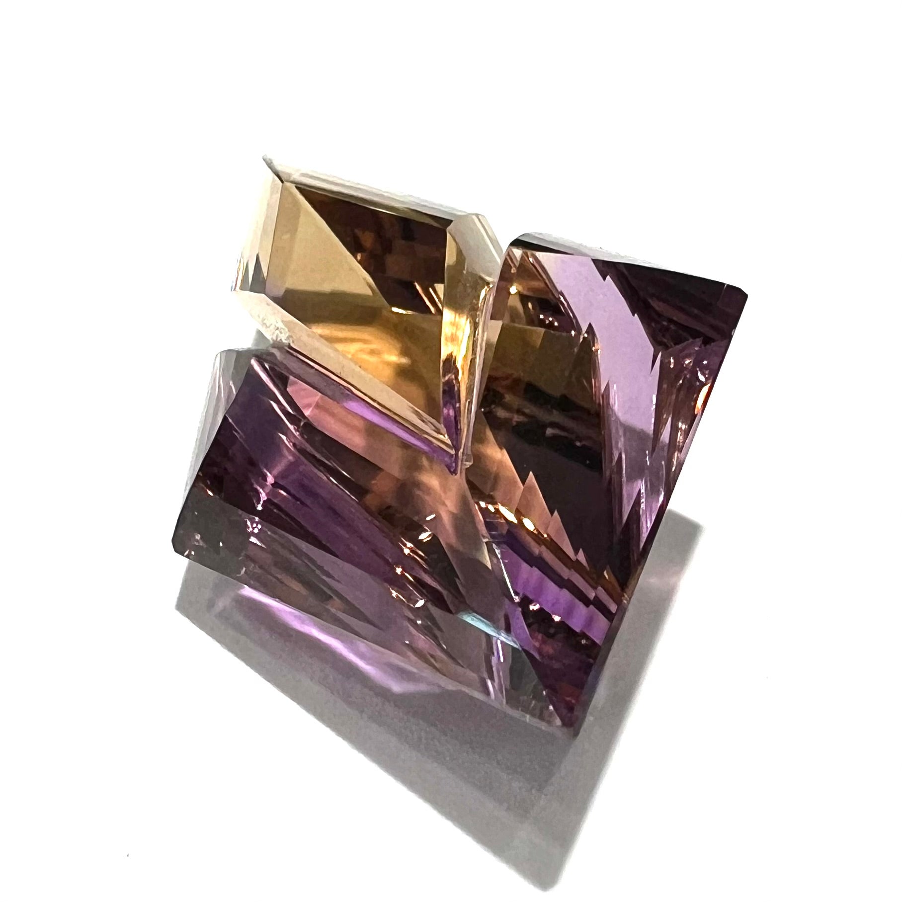 A loose, faceted fantasy cut ametrine gemstone cut by famous carver, Arthur Lee Anderson.