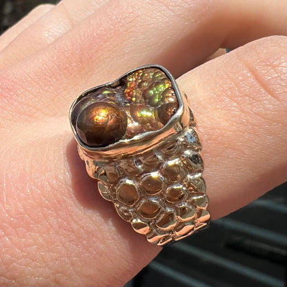 A men's yellow gold, nugget style ring set with a bubbly, California fire agate stone.