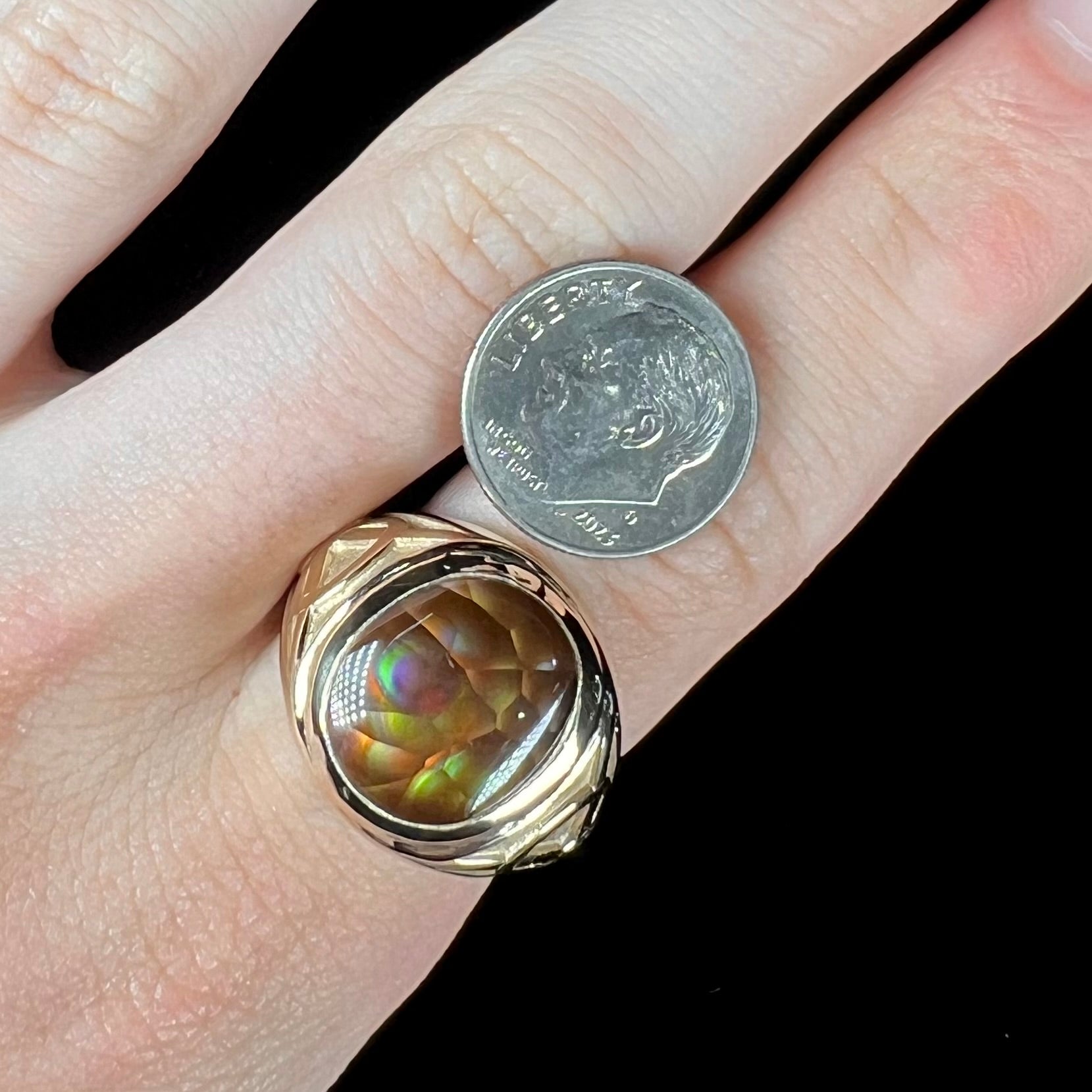 A men's solid yellow gold ring set with a Mexican fire agate stone.  The fire agate has a puple bull's eye pattern.