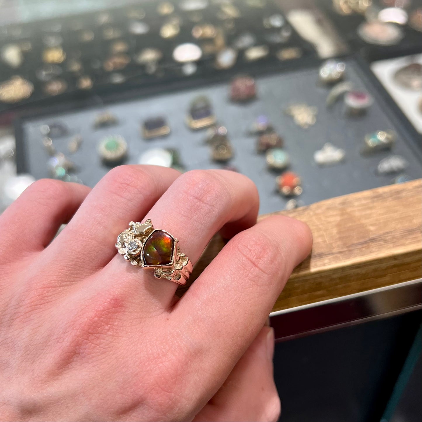 A men's yellow gold, nugget style ring set with a Mexican fire agate stone and a diamond accent.