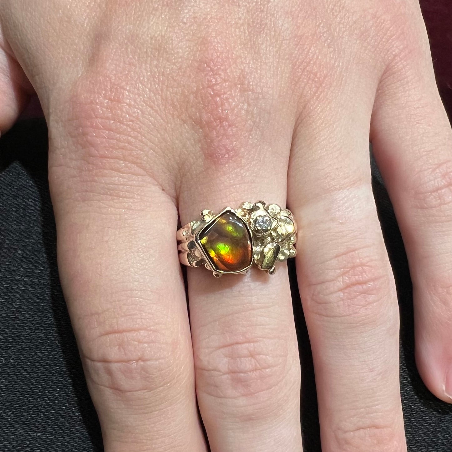 A men's yellow gold, nugget style ring set with a Mexican fire agate stone and a diamond accent.