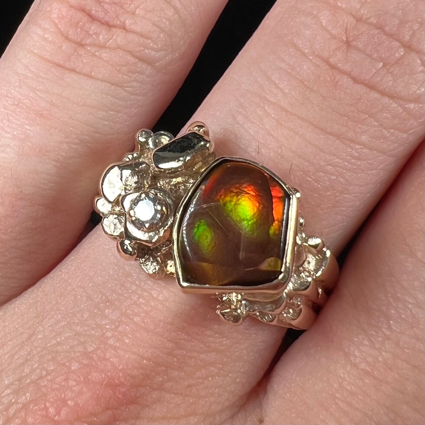 A men's yellow gold, nugget style ring set with a Mexican fire agate stone and a diamond accent.