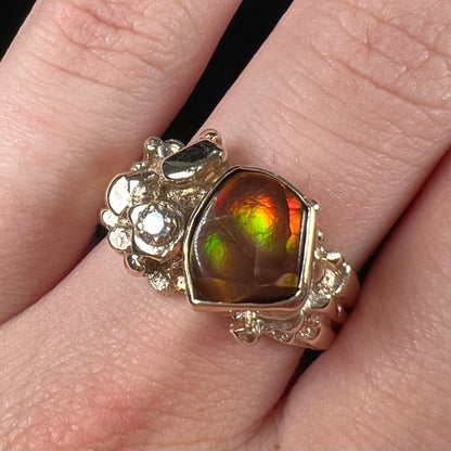 A men's yellow gold, nugget style ring set with a Mexican fire agate stone and a diamond accent.