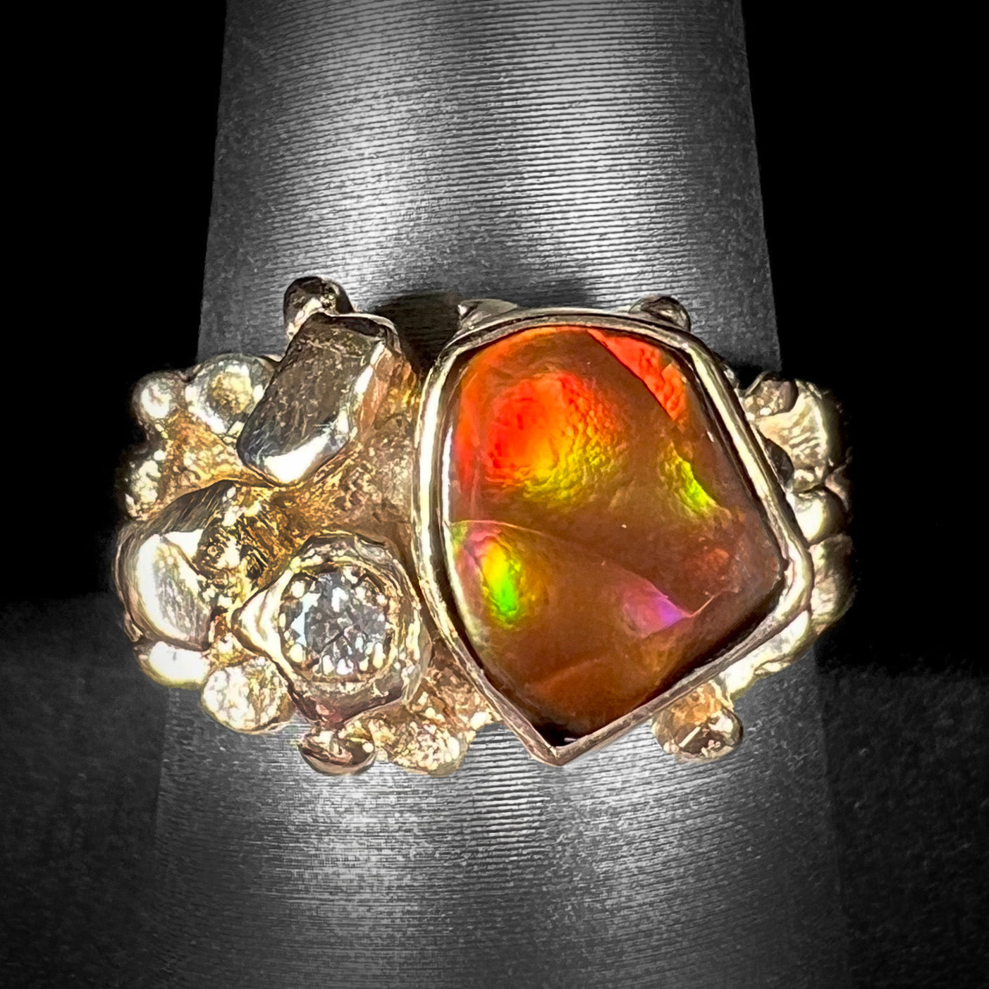 A men's yellow gold, nugget style ring set with a Mexican fire agate stone and a diamond accent.