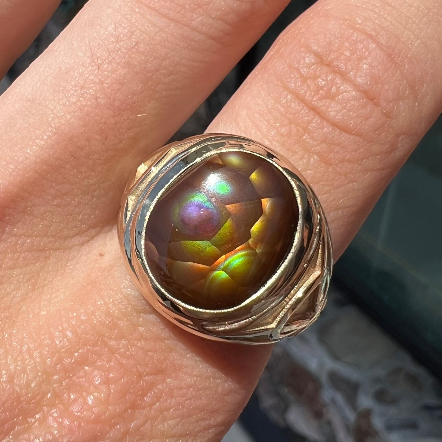 A men's solid yellow gold ring set with a Mexican fire agate stone.  The fire agate has a puple bull's eye pattern.