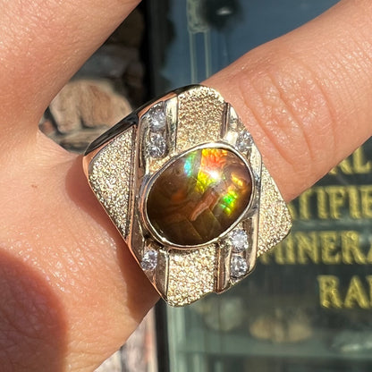 A yellow gold men's ring channel set with diamonds and bezel set with a Mexican fire agate stone.