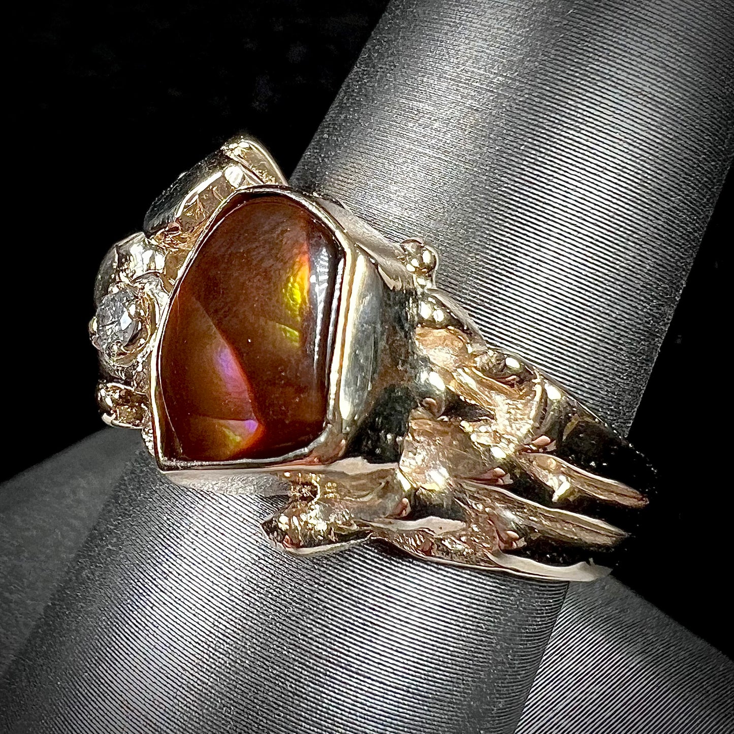 A men's yellow gold, nugget style ring set with a Mexican fire agate stone and a diamond accent.