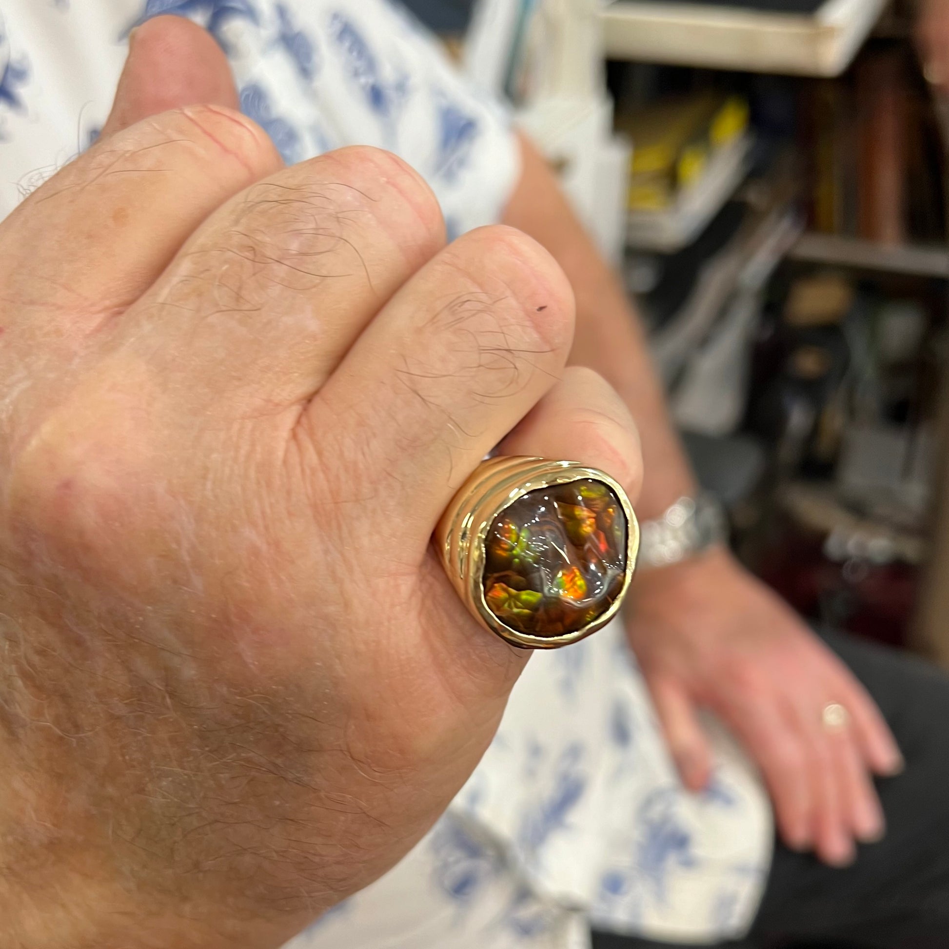 A men's heavy yellow gold ring set with a Mexican fire agate stone and three round brilliant cut diamond accents.