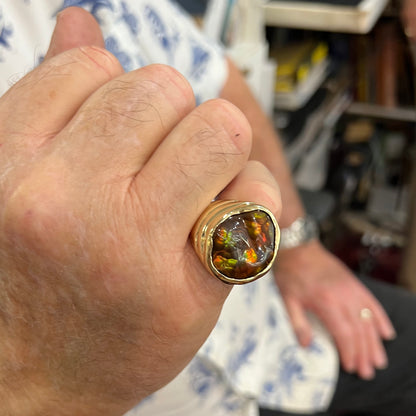 A men's heavy yellow gold ring set with a Mexican fire agate stone and three round brilliant cut diamond accents.