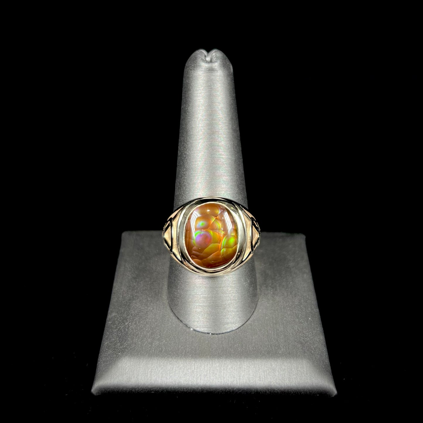 A men's solid yellow gold ring set with a Mexican fire agate stone.  The fire agate has a puple bull's eye pattern.