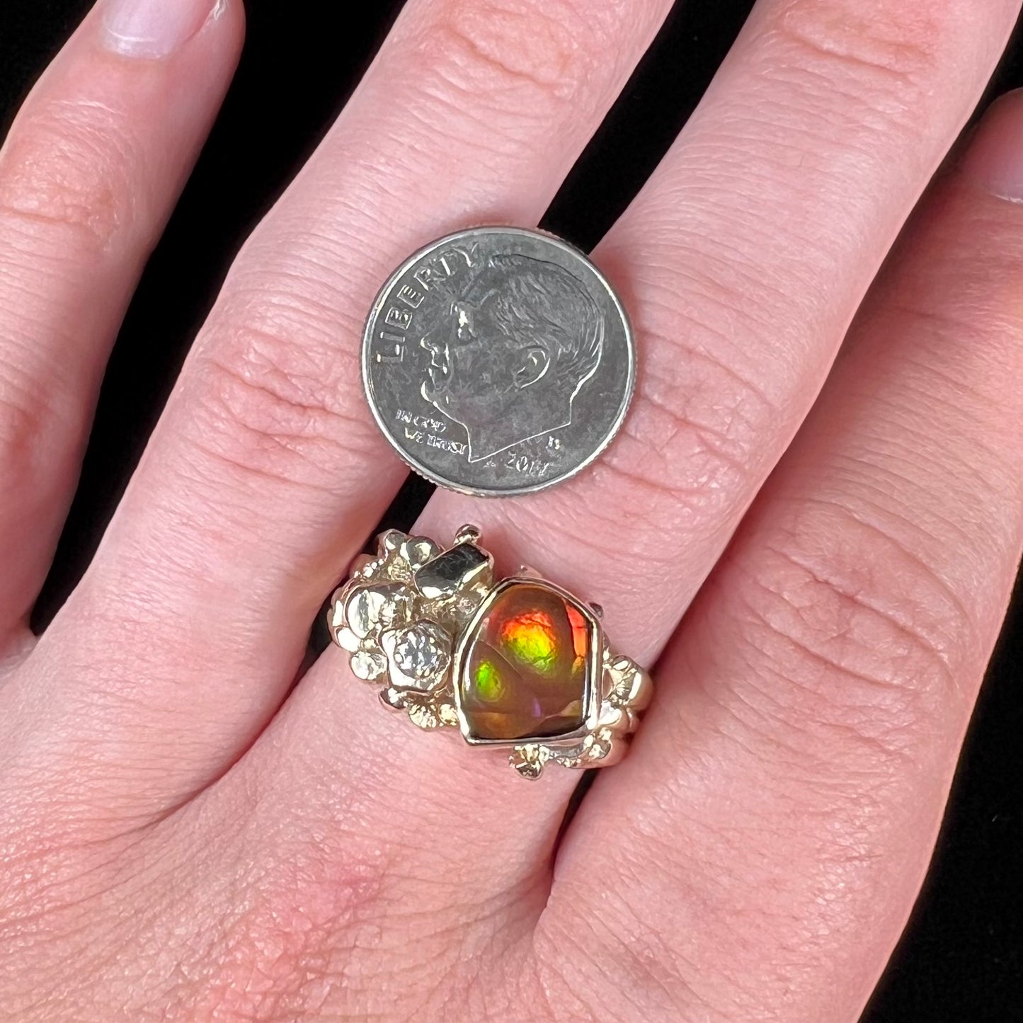 A men's yellow gold, nugget style ring set with a Mexican fire agate stone and a diamond accent.