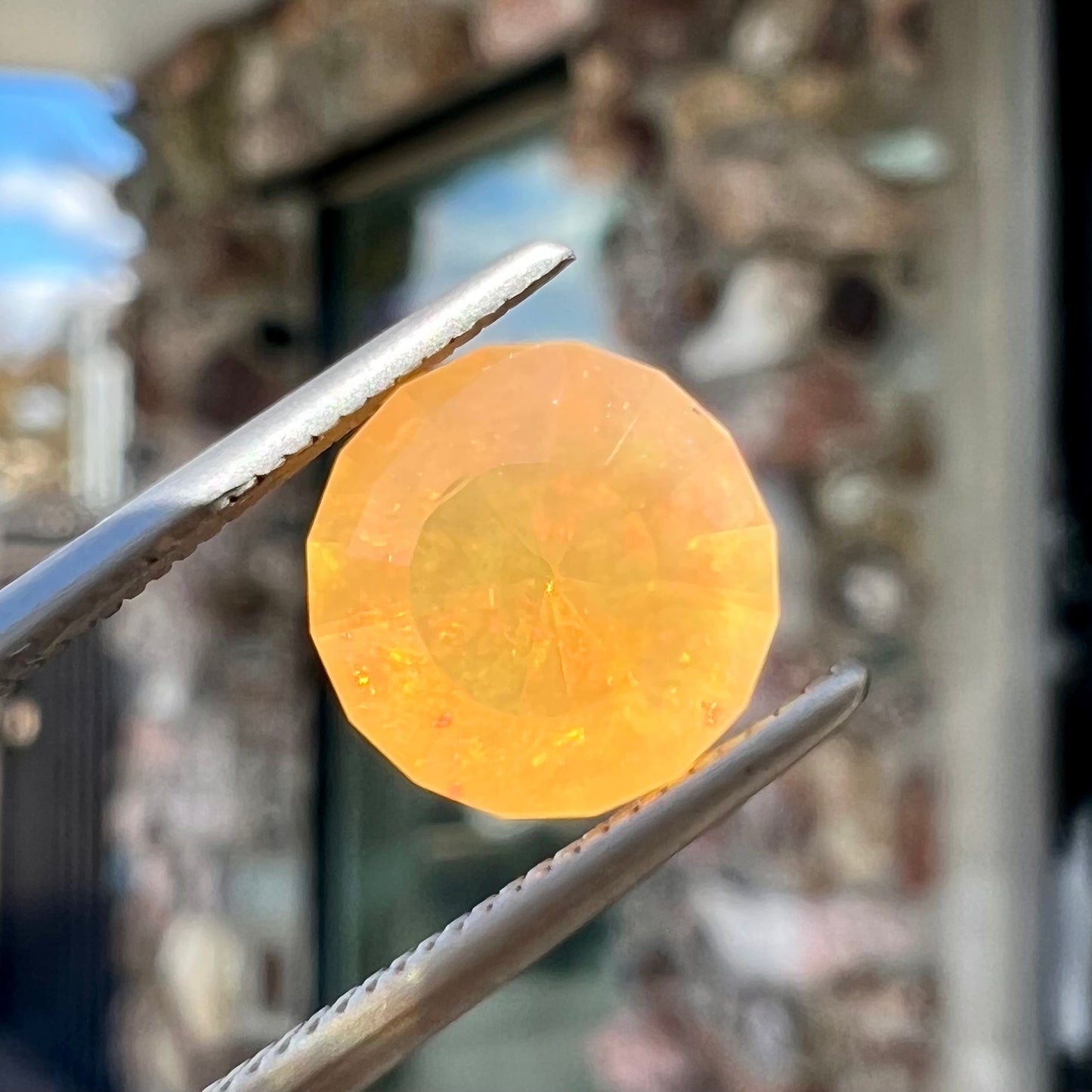 A loose, faceted round cut fire opal from Mexico.  The stone is yellow orange in body color.