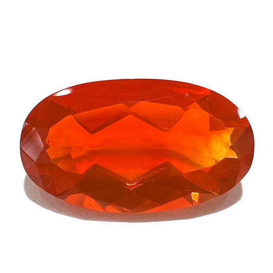 A loose, faceted oval cut Mexican fire opal stone.  The stone is a bright orange color.