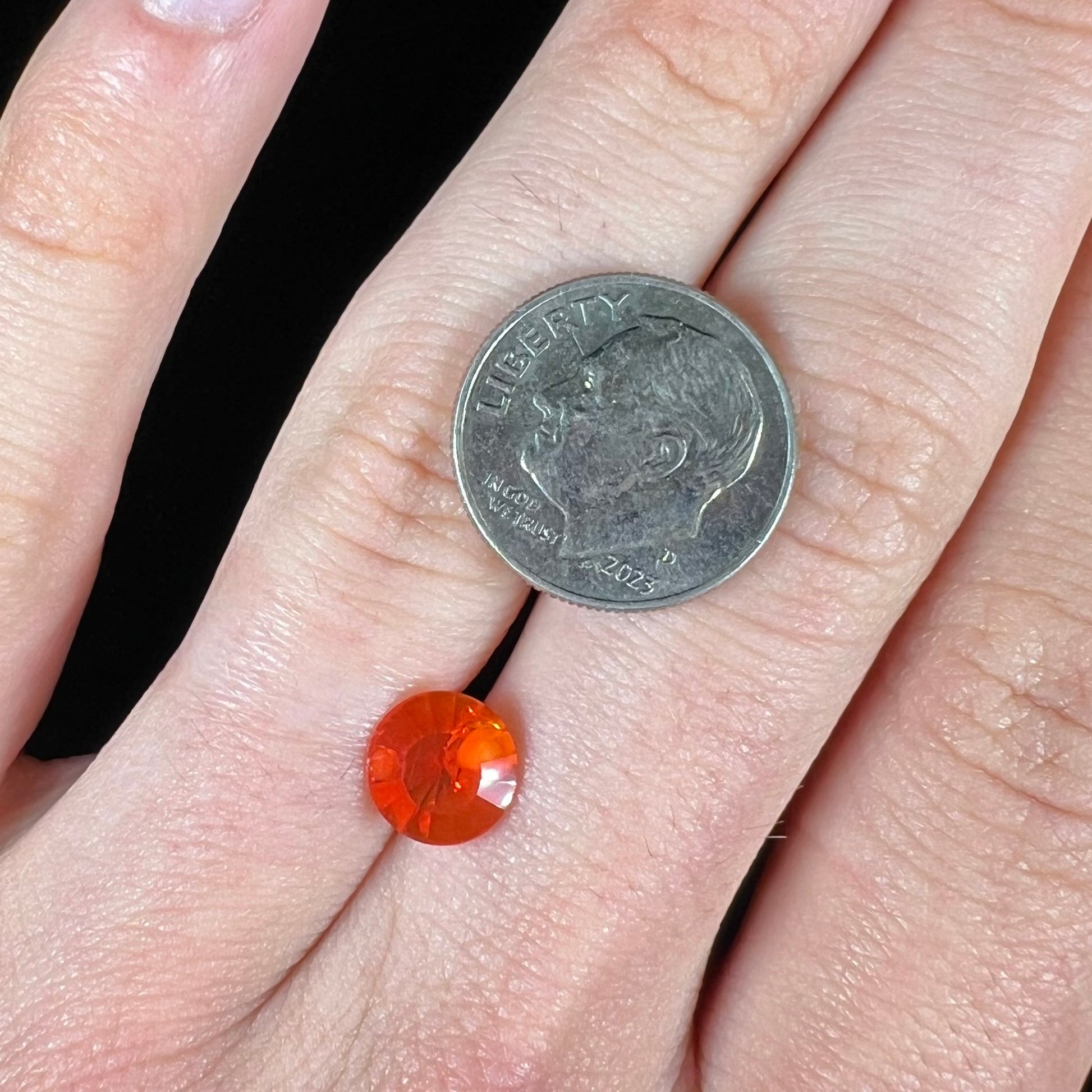 A faceted round cut natural fire opal from Mexico.  The stone is a bright orange color.