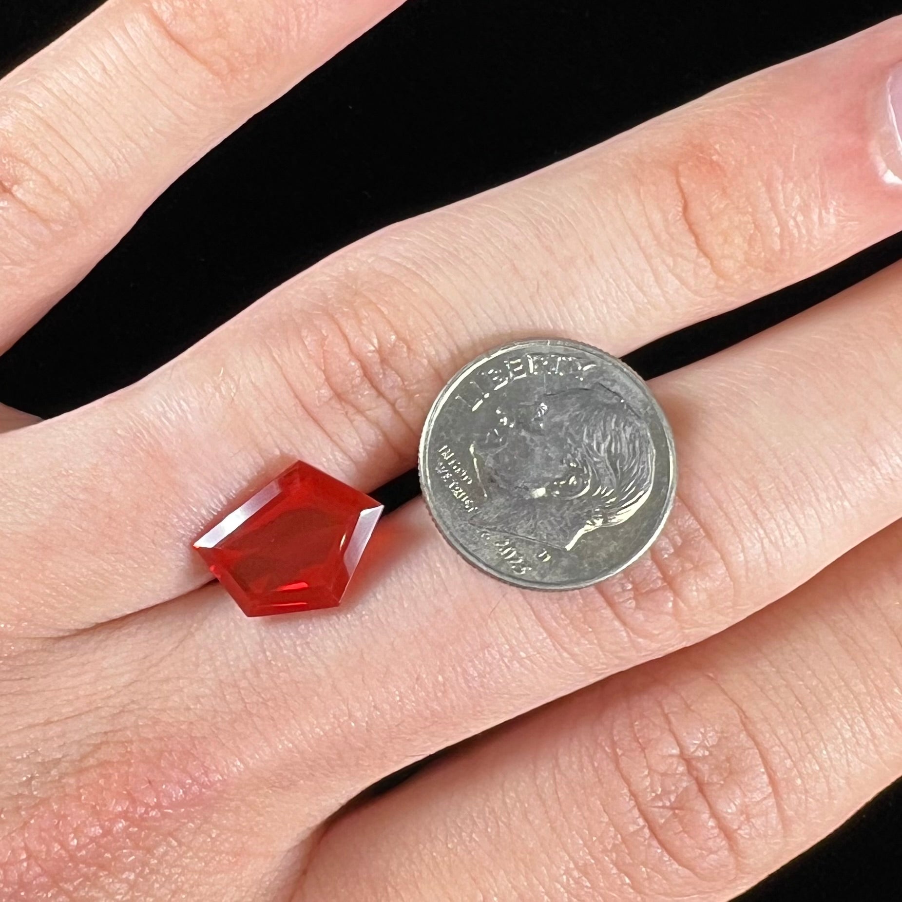A loose, faceted freeform cut Mexican fire opal gemstone.  The stone is a cherry red color.