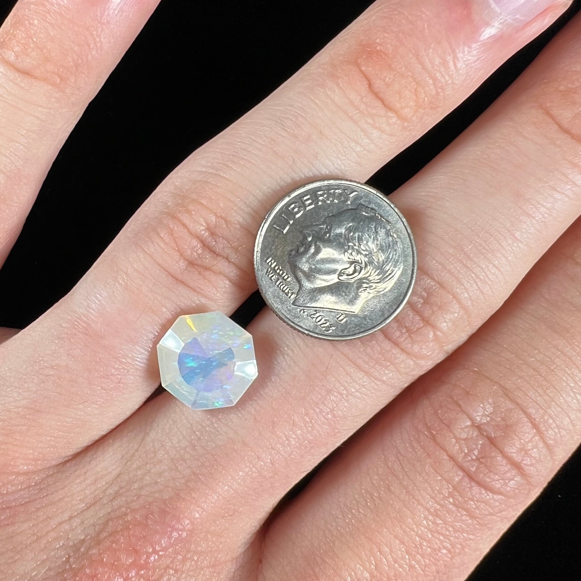 A loose, faceted octagon cut Mexican fire opal gemstone.  The stone is a light yellow color with blue and green fire.