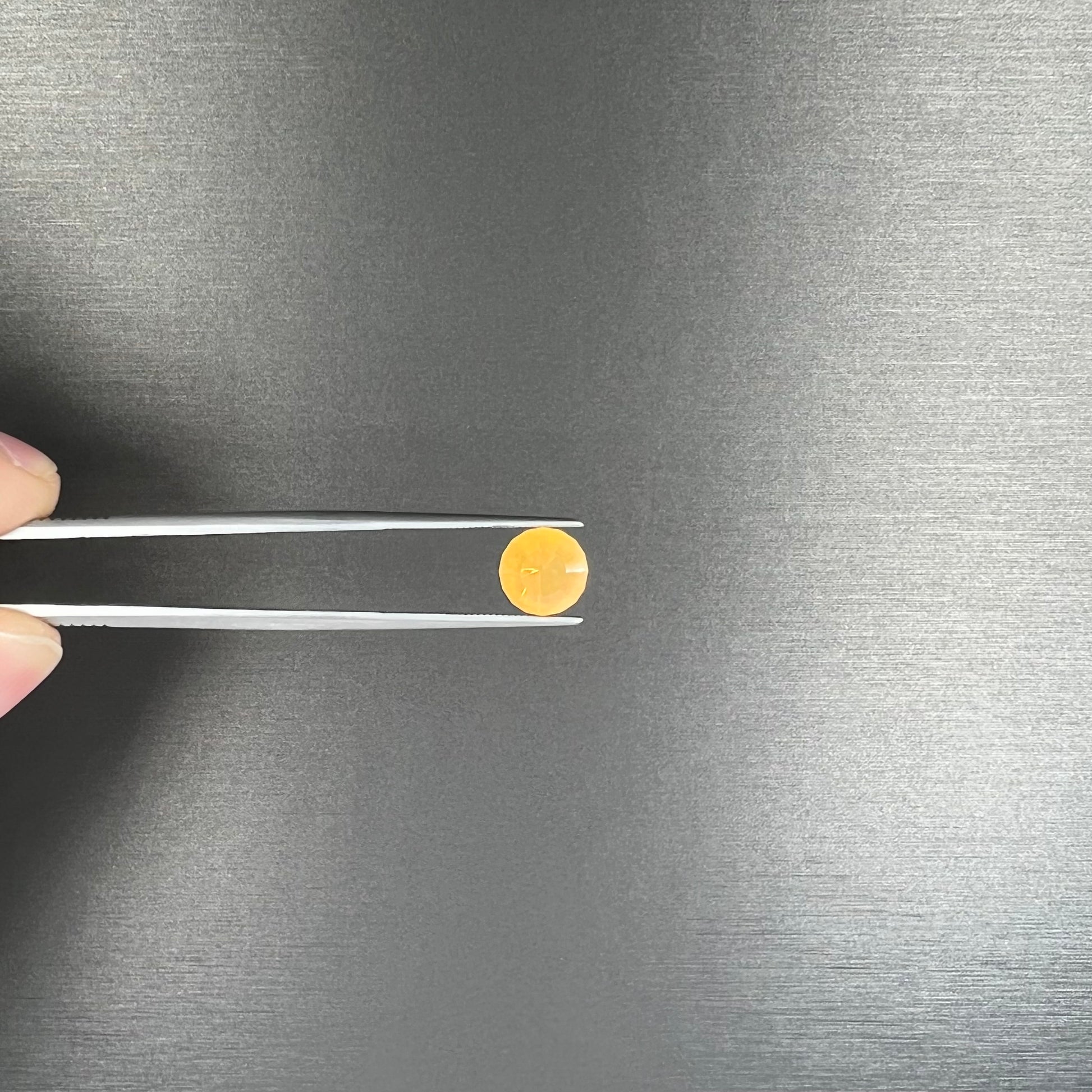A loose, faceted round cut fire opal from Mexico.  The stone is yellow orange in body color.