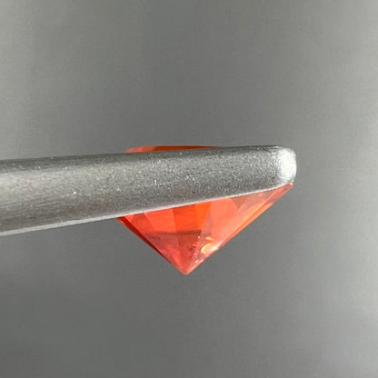 A faceted round cut natural fire opal from Mexico.  The stone is a bright orange color.