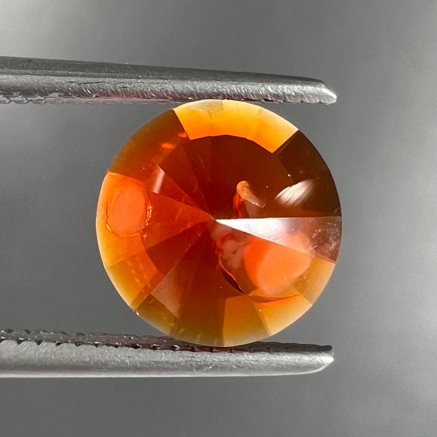 A faceted round cut natural fire opal from Mexico.  The stone is a bright orange color.