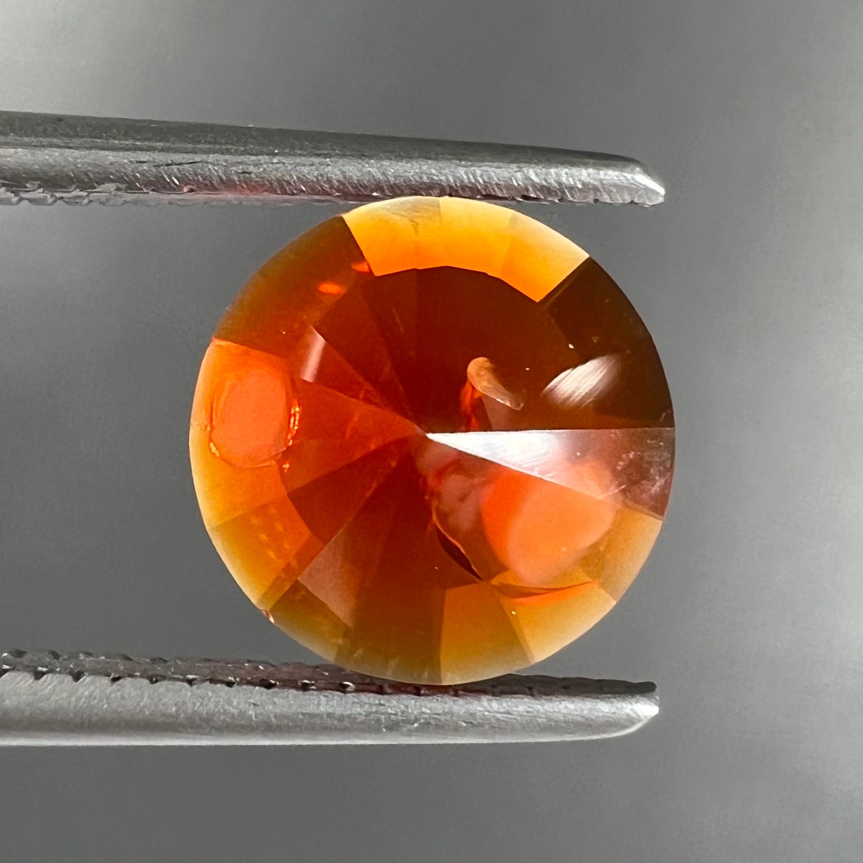 A faceted round cut natural fire opal from Mexico.  The stone is a bright orange color.
