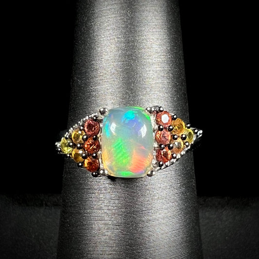 A ladies' silver ring set with a cushion cabochon cut Ethiopian fire opal stone and citrine accents.