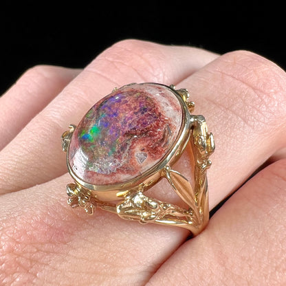 A ladies' estate yellow gold solitaire ring set with an oval cabochon cut natural Cantera fire opal.