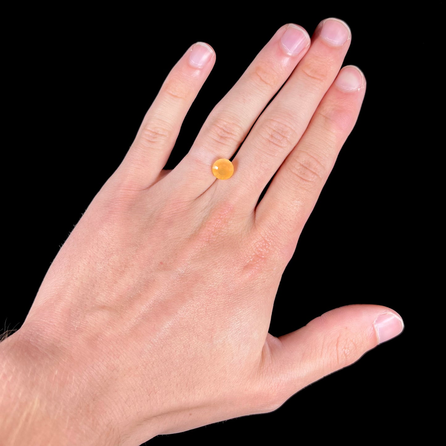 A loose, faceted round cut fire opal from Mexico.  The stone is yellow orange in body color.