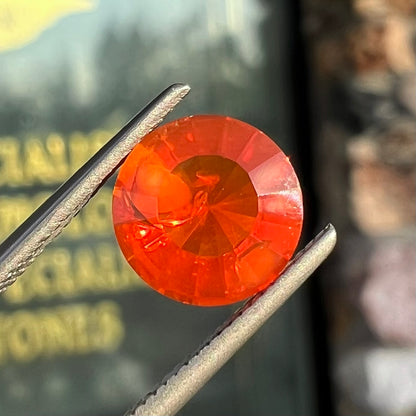 A faceted round cut natural fire opal from Mexico.  The stone is a bright orange color.