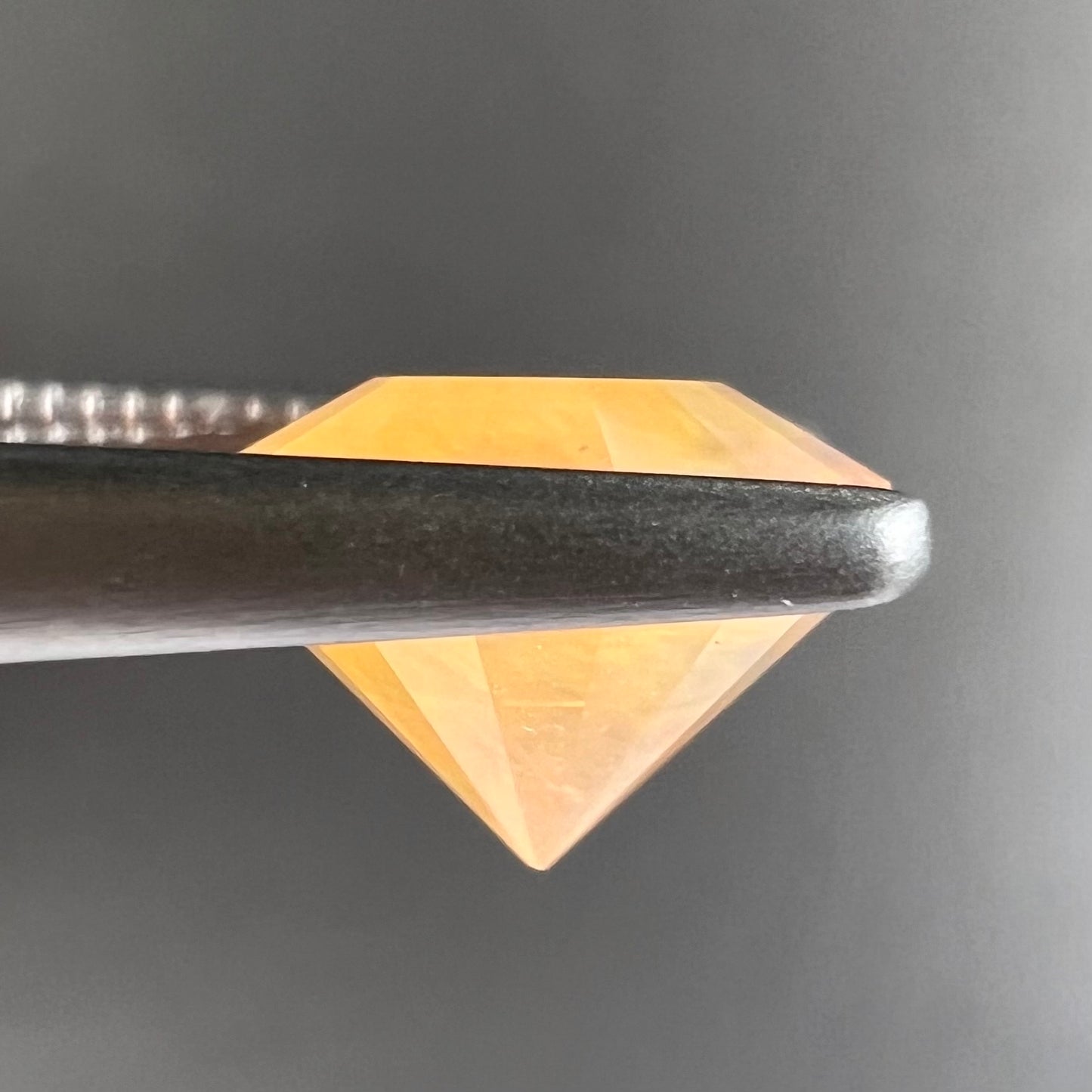 A loose, faceted round cut fire opal from Mexico.  The stone is yellow orange in body color.