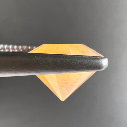 A loose, faceted round cut fire opal from Mexico.  The stone is yellow orange in body color.