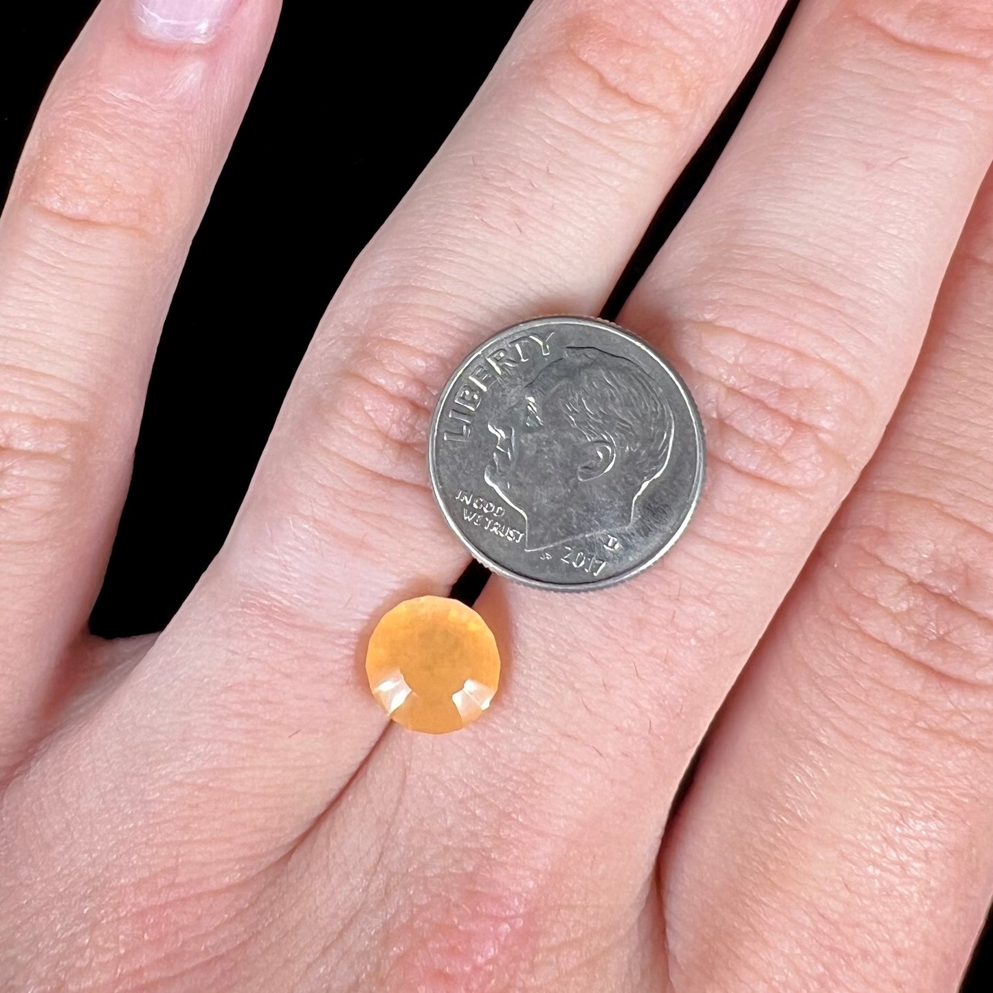 A loose, faceted round cut fire opal from Mexico.  The stone is yellow orange in body color.