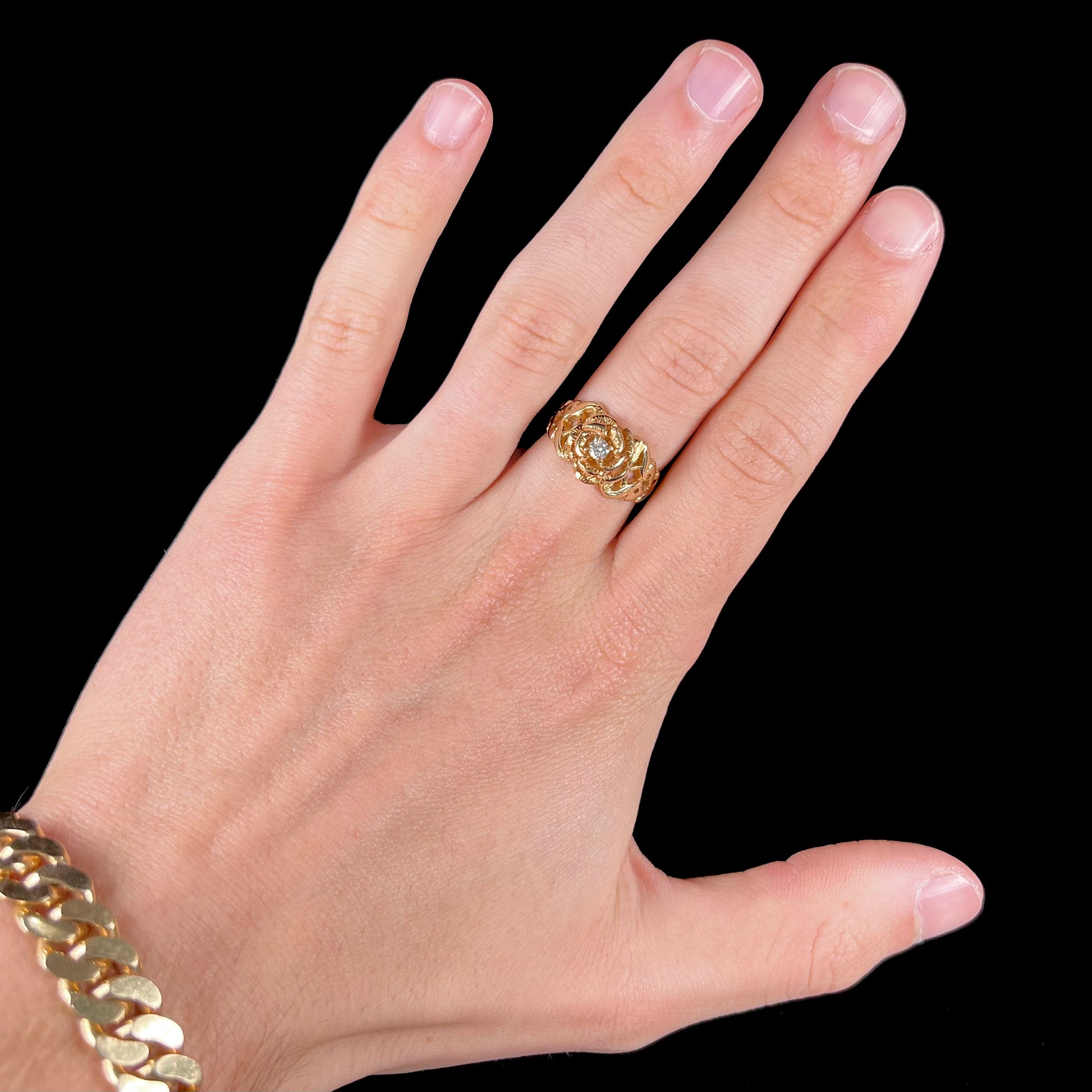 A ladies' yellow gold rose style ring set with a natural 0.10ct diamond.