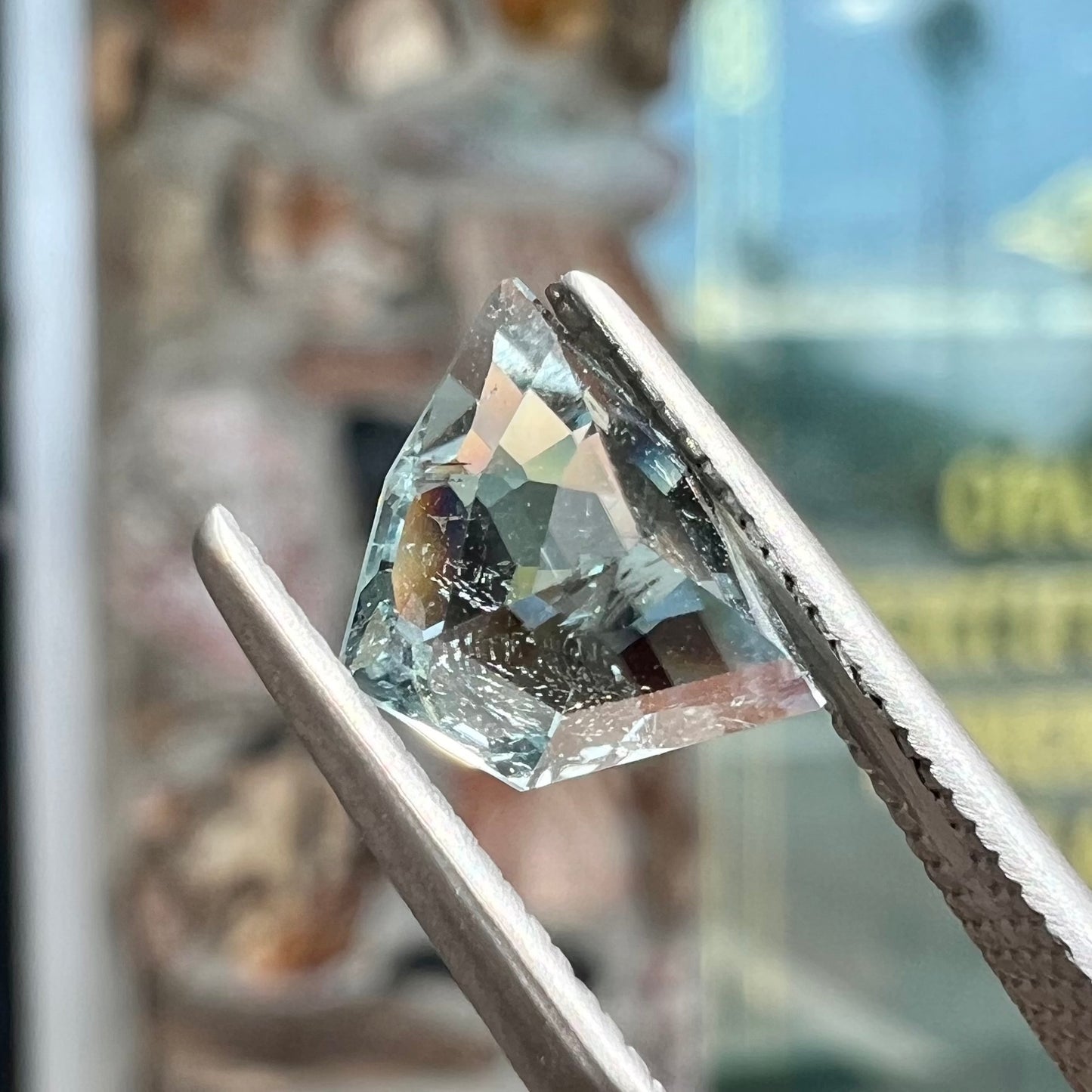 A loose, freeform shield cut tourmaline gemstone.  The stone is a steel blue color.