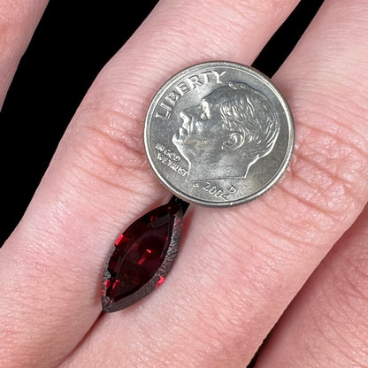 A faceted marquise cut red pyrope garnet stone.