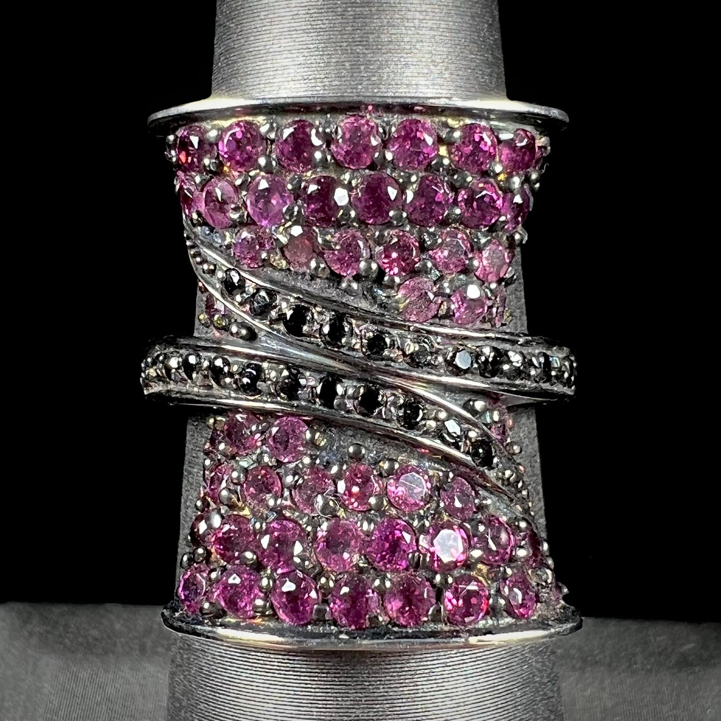 A ladies' bow-shaped designer ring pave set with purple rhodolite garnets and black spinel accents.