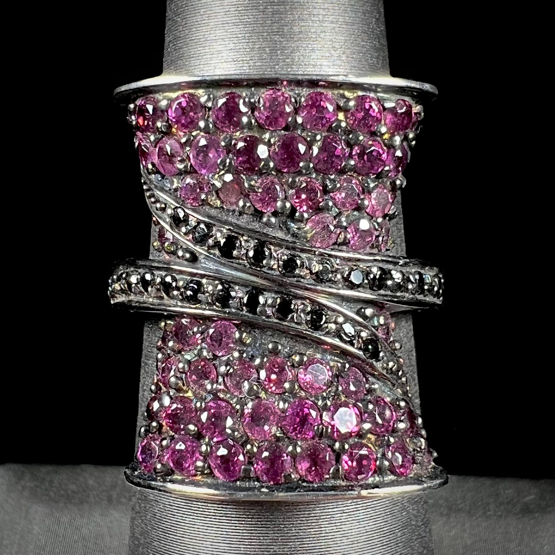 A ladies' bow-shaped designer ring pave set with purple rhodolite garnets and black spinel accents.